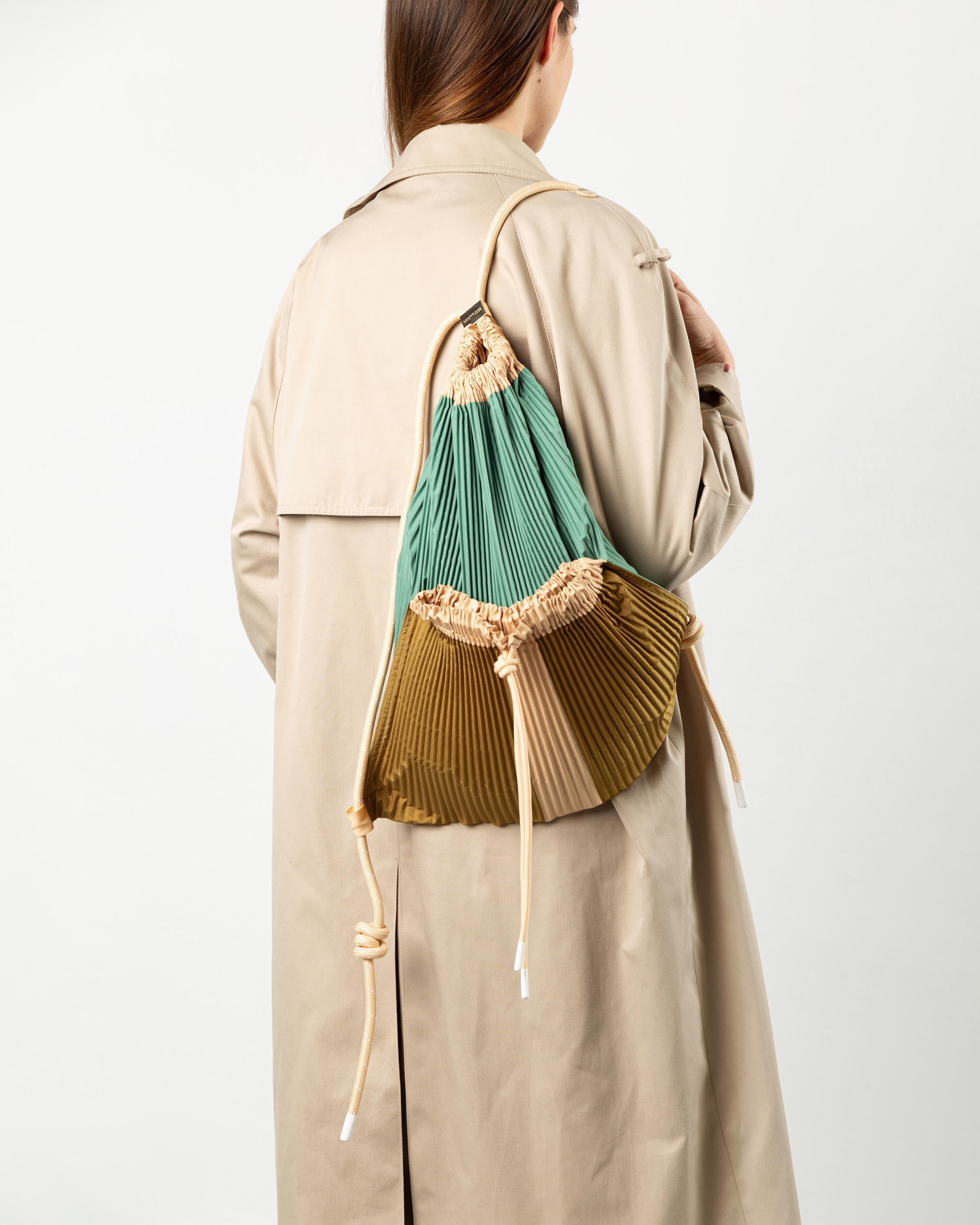 Zaino plissettato Gae Multitudes indossato sulle spalle per un outfit casual chic.