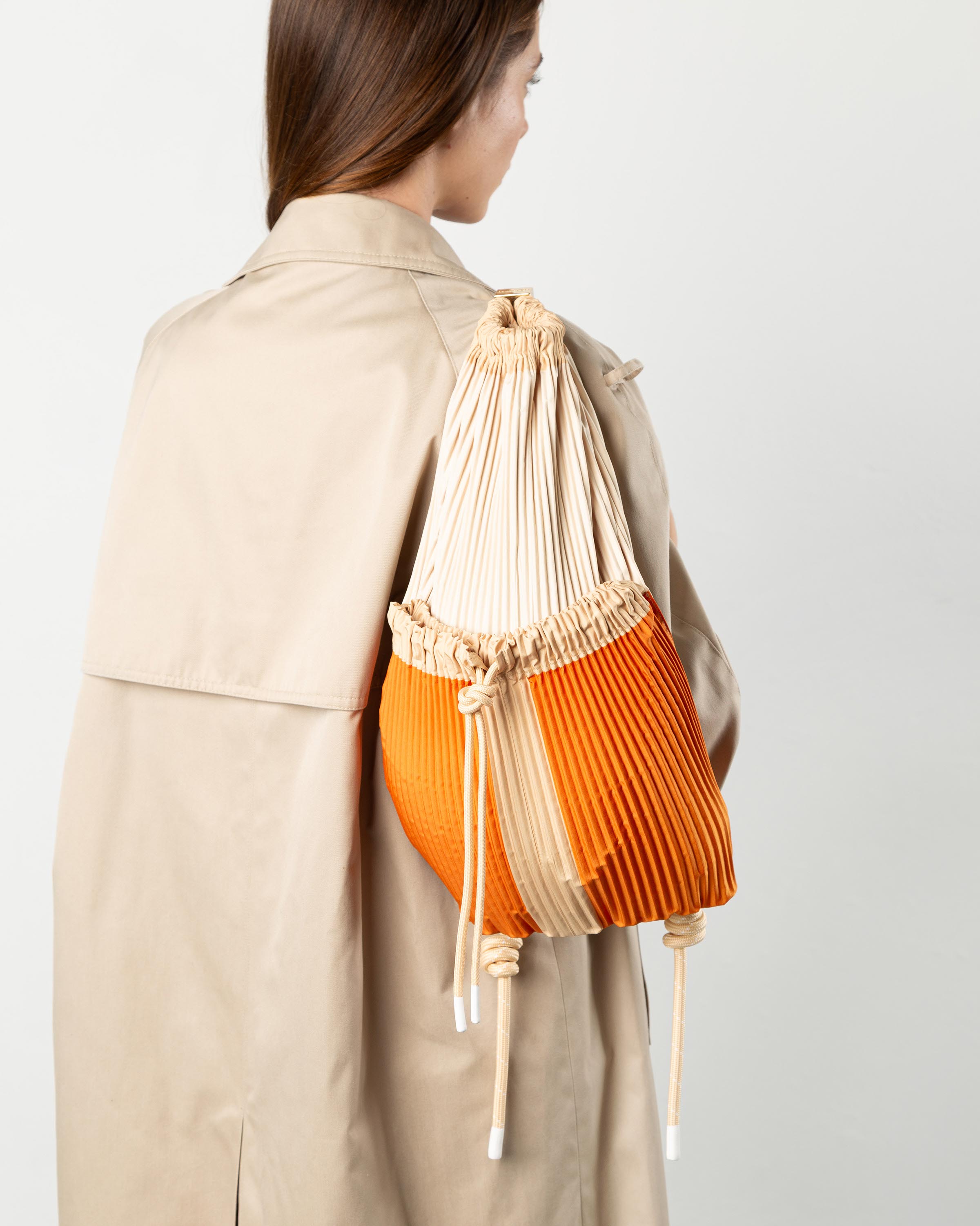 Zaino plissettato Nanda Multitudes indossato sulle spalle per un outfit casual chic.