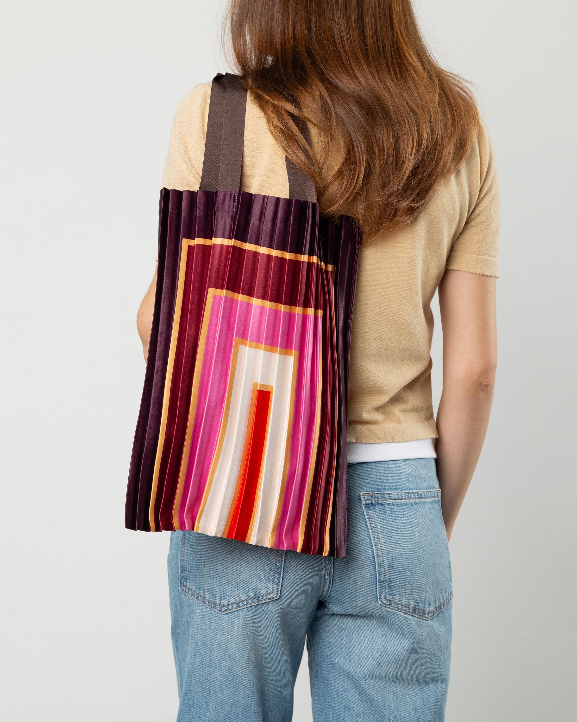 Dettaglio del tessuto plissettato in raso lucido effetto seta di una borsa di design Multitudes, lavorazione artigianale.