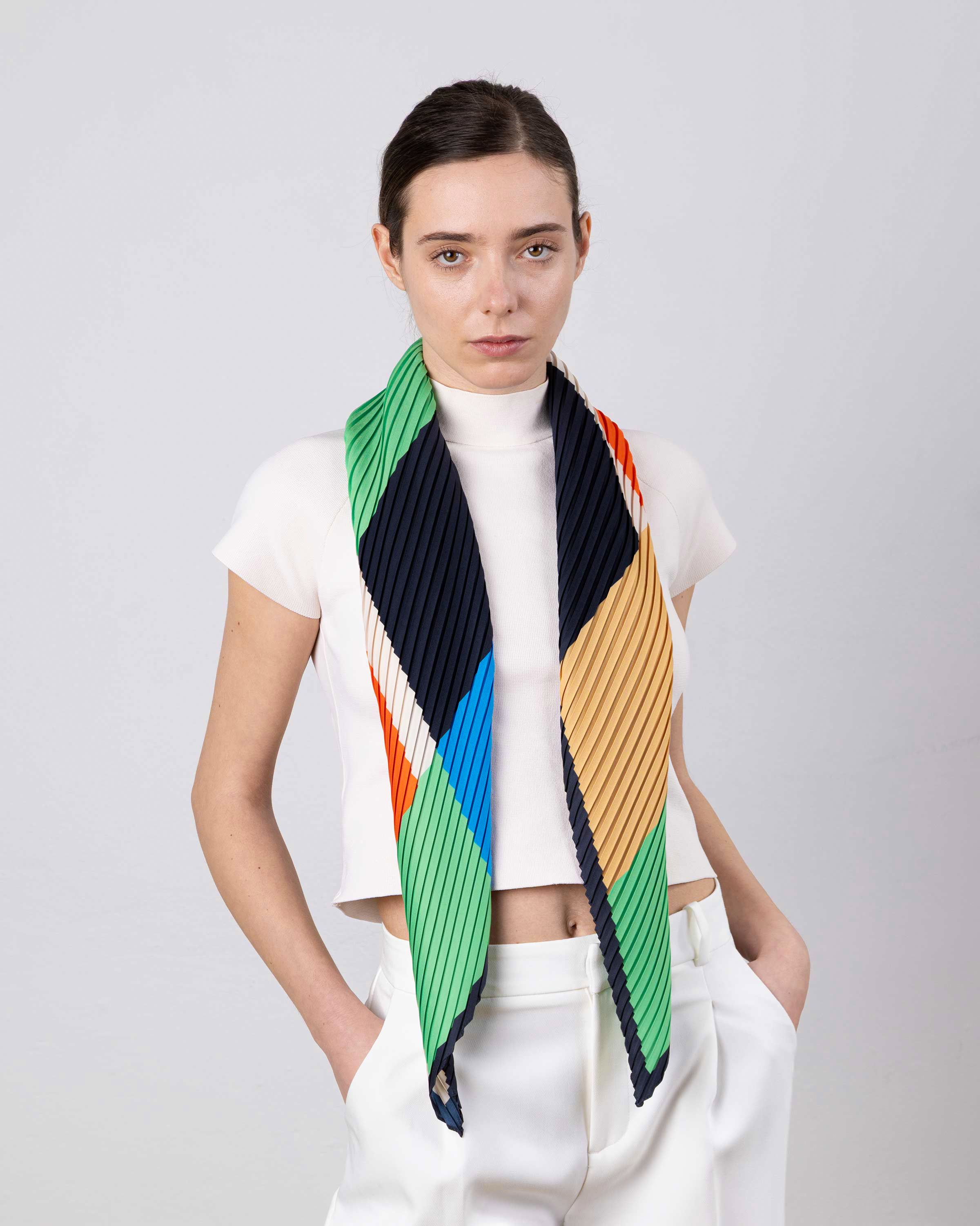 Modella che indossa la sciarpa plissettata Afrodite verde e rossa di Multitudes.