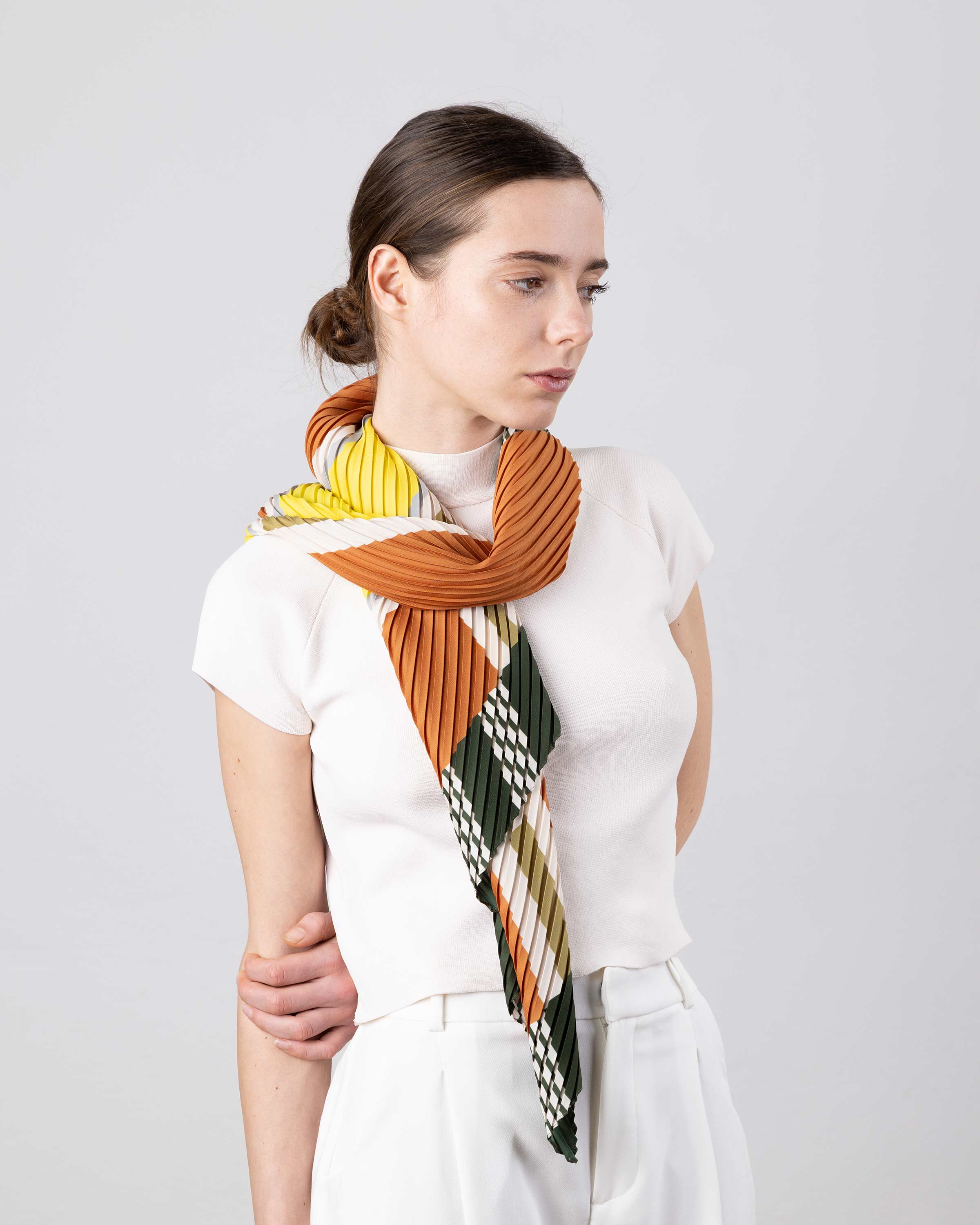Sciarpa plissettata Selene beige e bronzo Multitudes indossata annodata al collo.