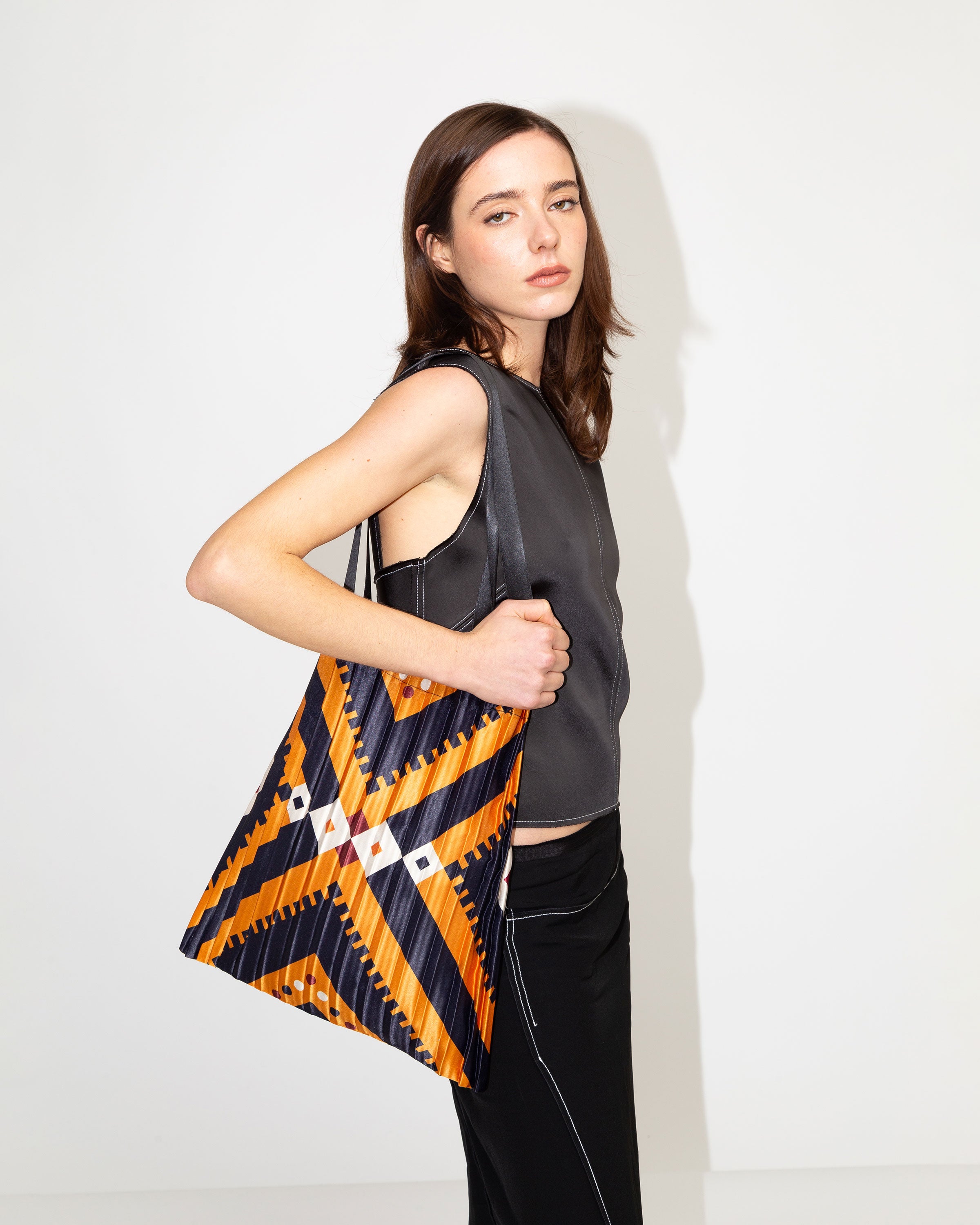 Tote Bag Alghero di Multitudes indossata. Color arancione con righe più scure.