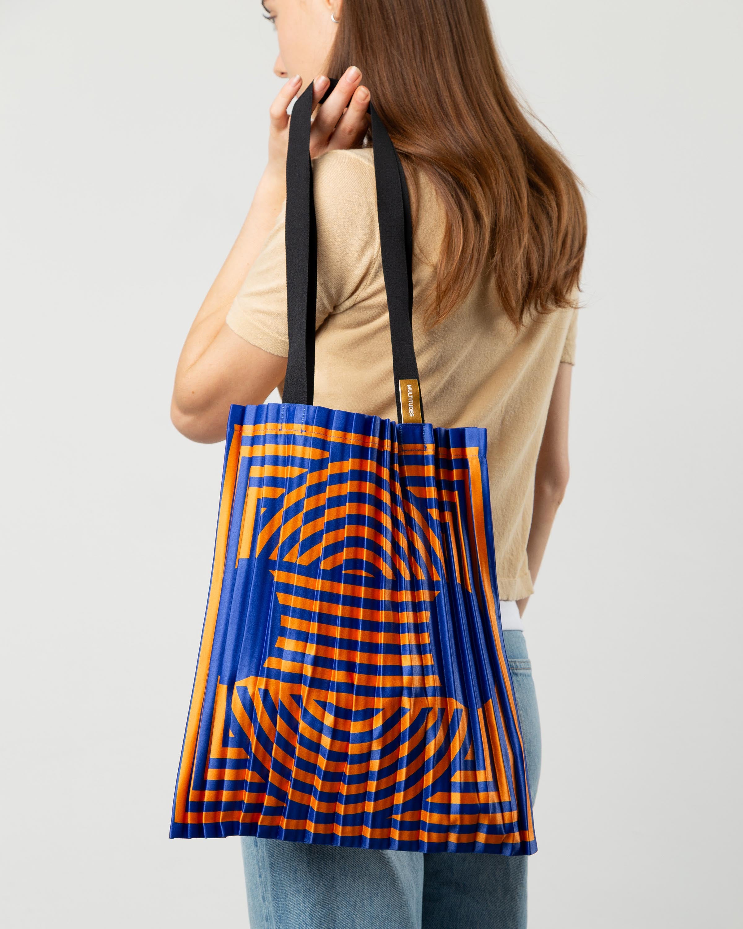 Tote bag Marzamemi di Multitudes indossata. Colore arancione e blu elettrico.