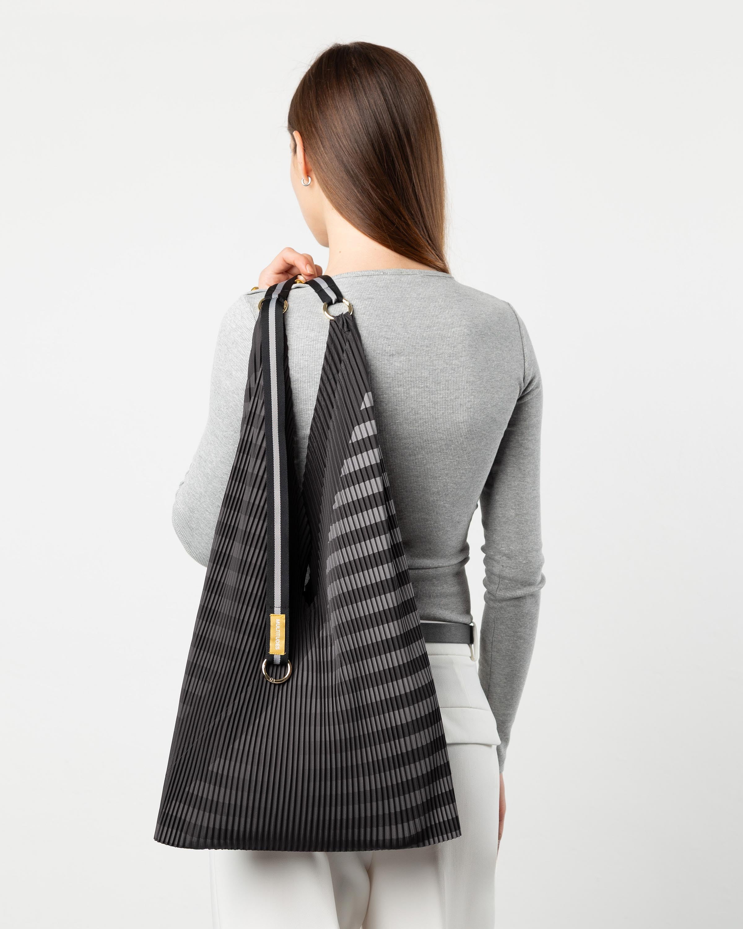 Modella che indossa la borsa plissettata Claudia Black di Multitudes.