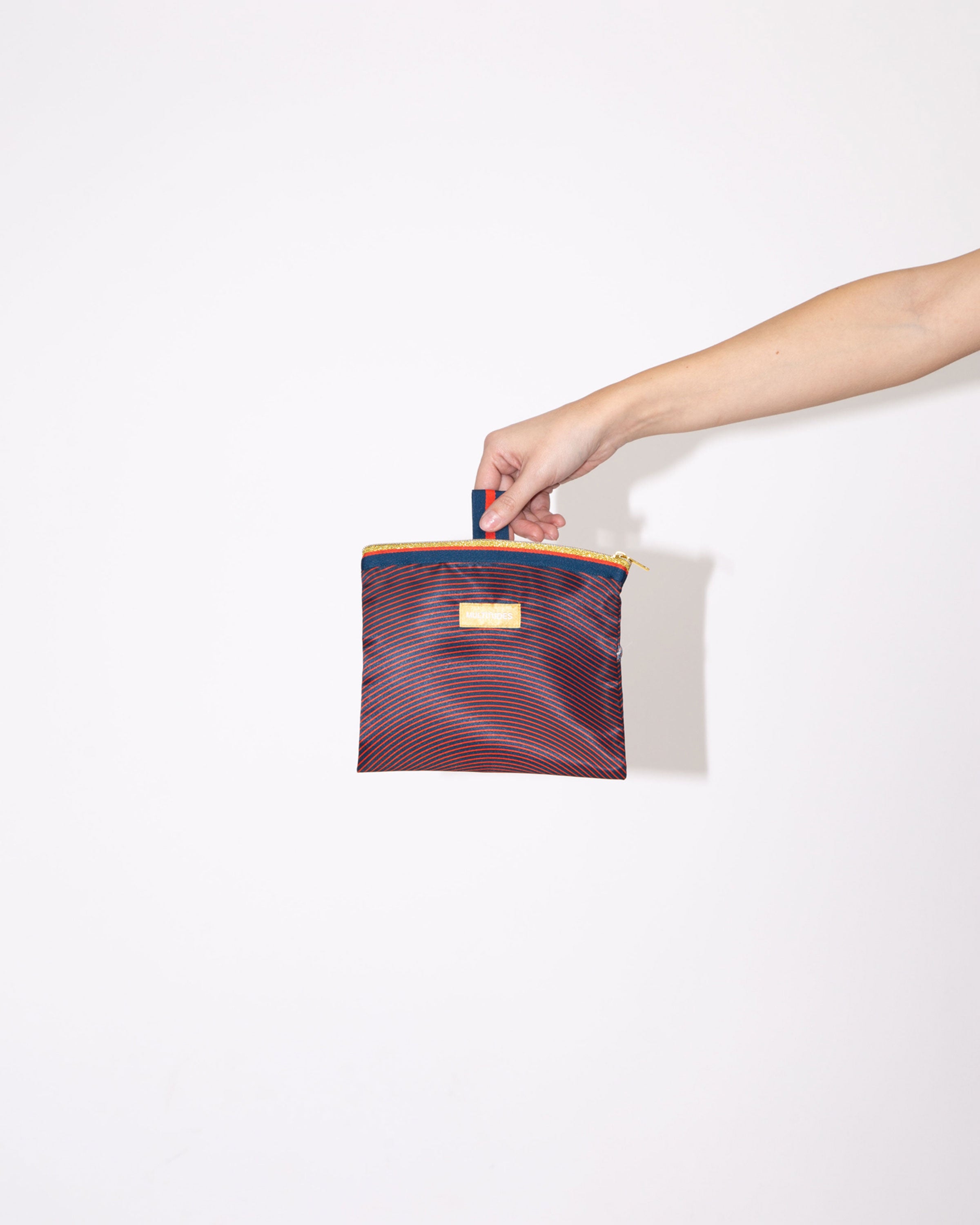 Pochette Isabella Blue di Multitudes indossata. Rosso e blu navy.