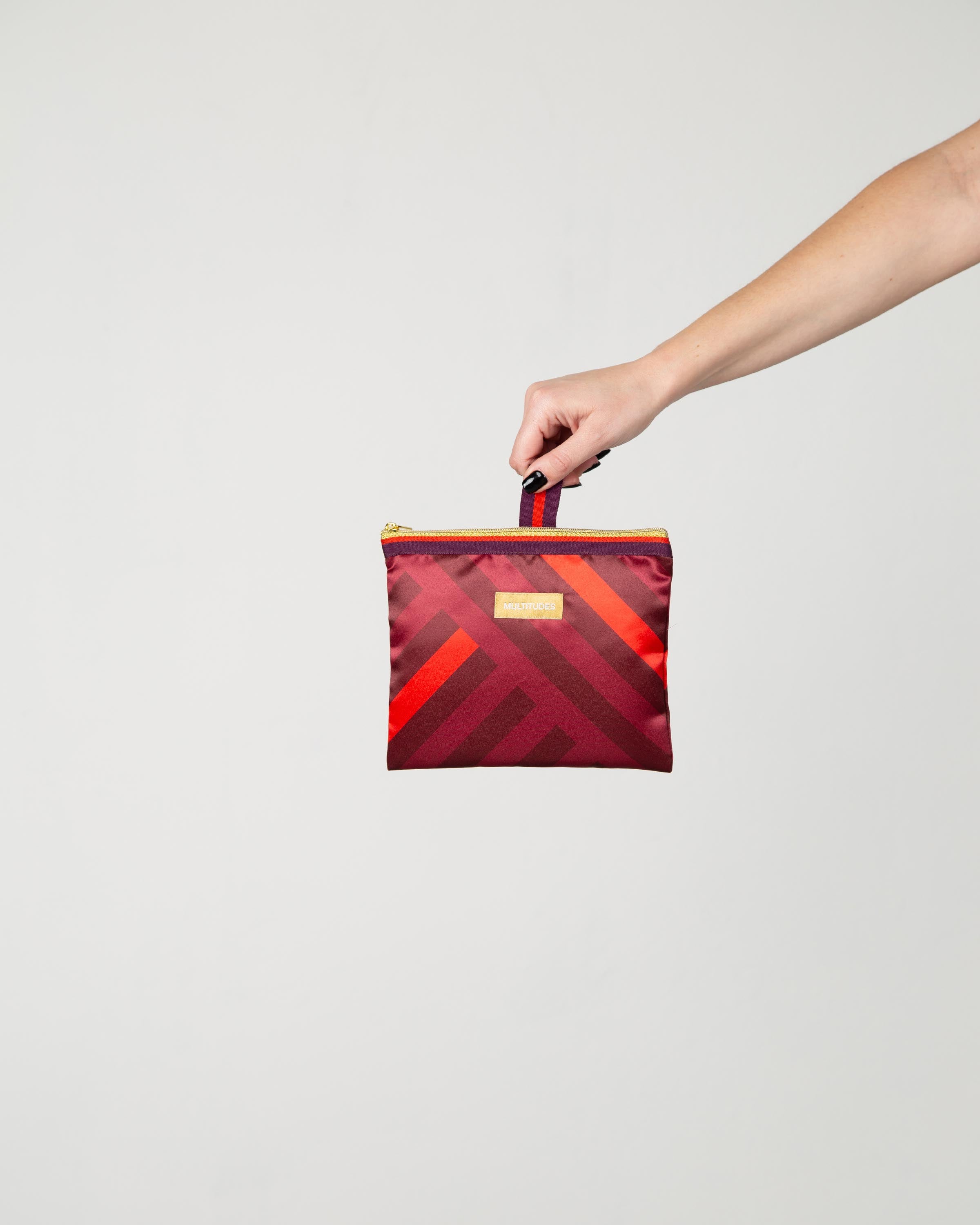Pochette Stefania di Multitudes indossata. A righe rosse, viola e borgogna.
