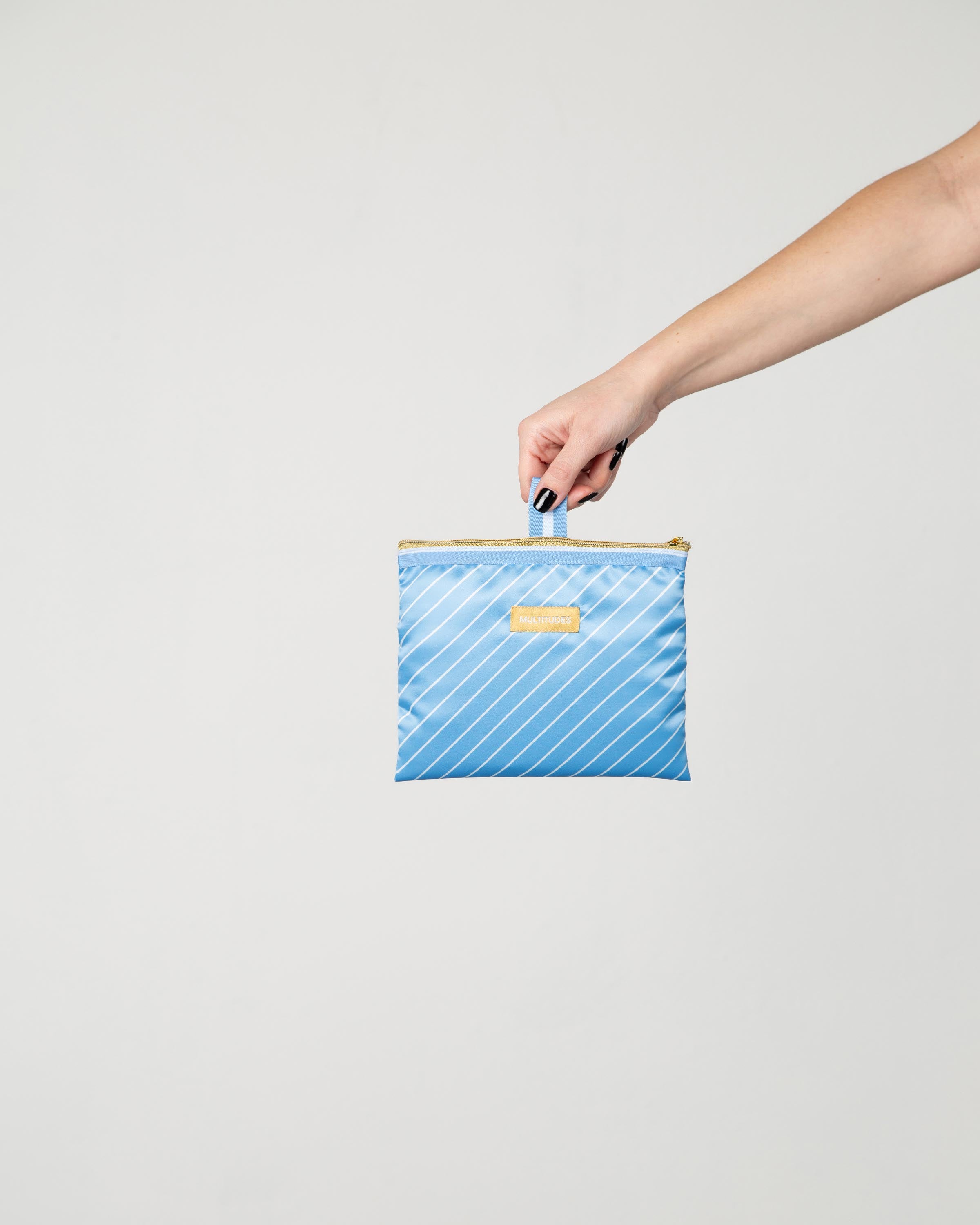 Pochette Susan di Multitudes indossata. Azzurro cielo a righe bianche.